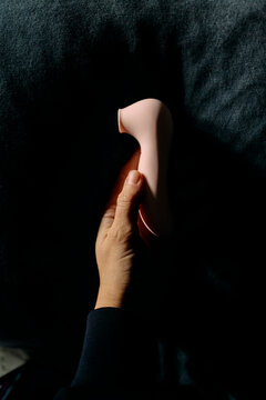 Hand holding a pink vibrator