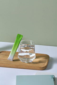 A glass of water with green tea packet