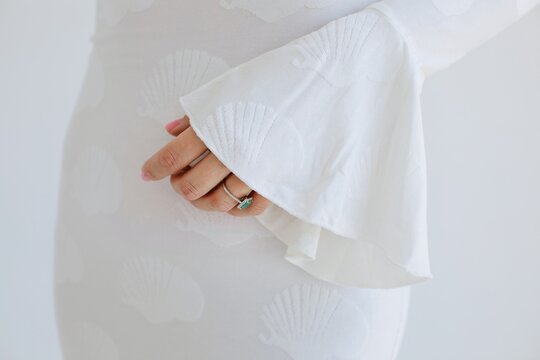 Crop hand of anonymous woman in white dress 