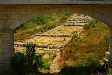 most nad wyschniętym korytem rzeki, sucha rzeka w Hiszpani, wysuszone koryto rzeki bez wody, a bridge and a dried-out riverbed without water, dried up riverbed 