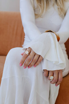 fashion portrait of anonymous woman in white dress with gold jewelry