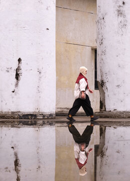 Chinese woman standing by the pool in the old building