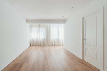 Empty white-walled room with wood flooring
