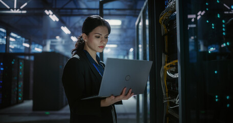 Engineer using laptop computer in data center.