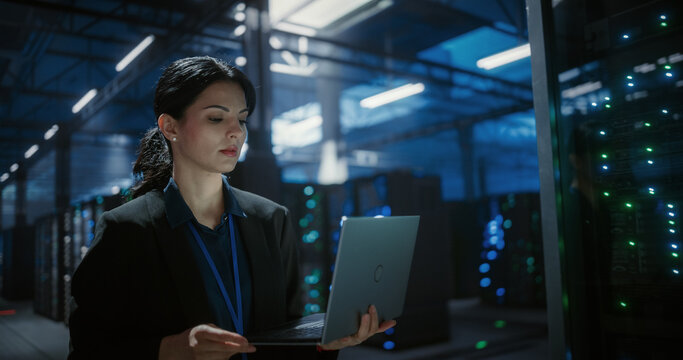 Engineer using laptop computer in data center.