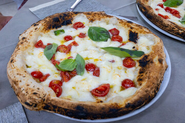 Eating of fresh baked Naples pizza dish in italian pizzeria restaurant, close up