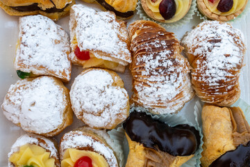 Italian sweet dessert dolce pastry and cakes with cream and fruits on plate made in artisanal bakery in Rome, Italy, close up