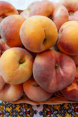Fresh ripe sweet yellow and flat peaches Prunus persica or doughnut peach or Saturn peach