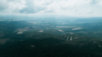 Aerial view over Divcibare, Serbia, showing vast forested hills, valleys, and dramatic clouds above the landscape