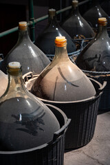 Dame Jeanne or demijohn glass jars for aging of natural sweet red grand cru wine Banyuls fortified dessert wine from old vines from slopes of the Catalan Pyrenees in Roussillon, France.