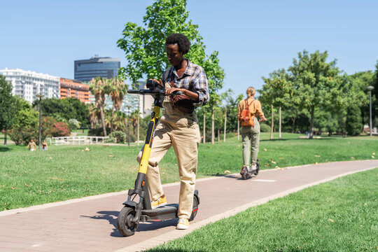 Woman using map app on smartphone while riding electric scooter