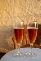 Summer vacation on Mediterranean sea, drinking cold rose champagne, cava sparkling wine in glass in sunlights, Collioure, Occitanie, South of France, tourists destination