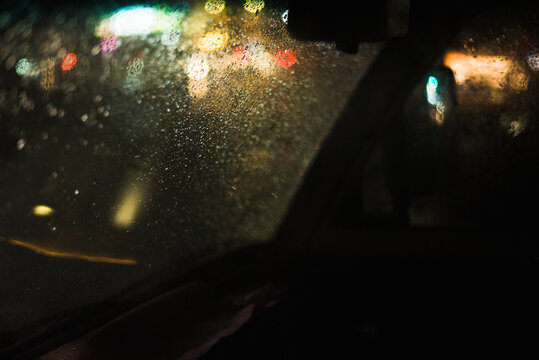 Raindrops and City Light Through a Car Window - Powered by Adobe