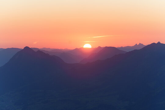 Sun rising over the mountain layers of the alps