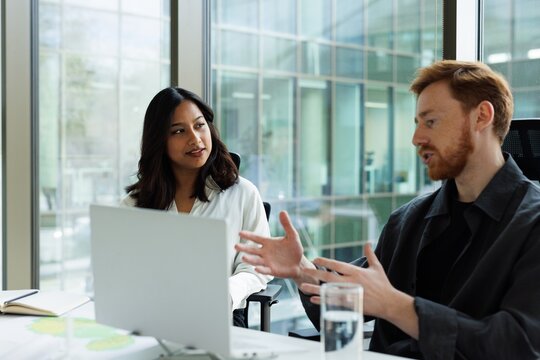Beautiful female architect listening male colleague during meeting