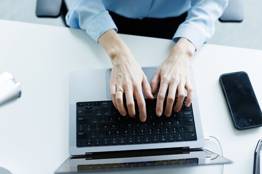 Top partial view of businesswoman using laptop computer at desk