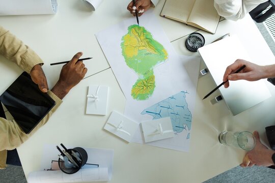 Top view of cropped architects discussing and looking at physical map