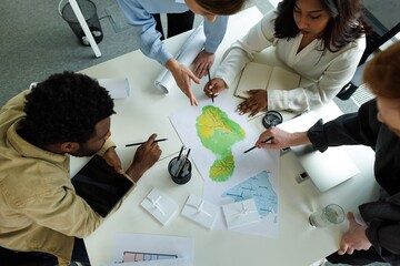 Top of concentrated architects discussing and looking at physical map