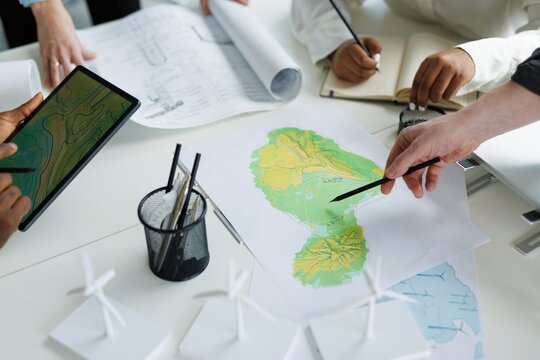 Partial architects looking at physical map of future windmill farm
