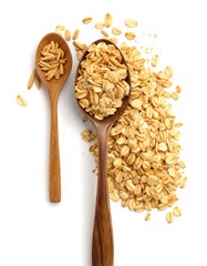 Wooden spoons holding and surrounded by scattered rolled oats against a white background