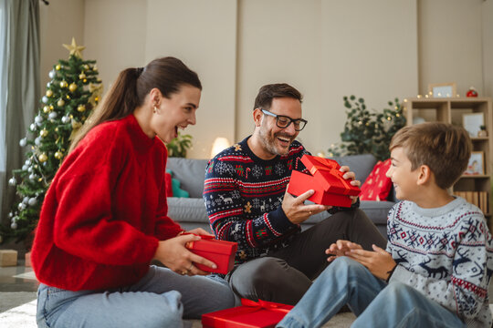 Happy family opening christmas gifts at home