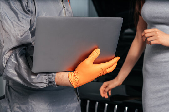 Closeup view of Car mechanic communicating with a female customer while using laptop and examining vehicle breakdown at auto repair shop