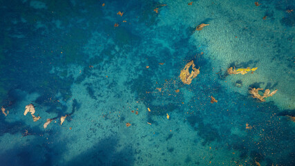 Aerial photo of clear blue sea with rocks visible under water peaceful summer scene and popular...