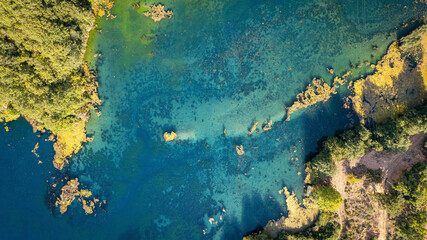 Aerial photo of coastal lagoon with turquoise blue water rocky shoreline and green forest natural landscape and scenic travel photography spot