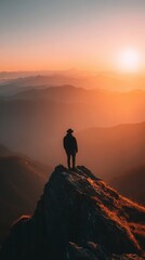 Fototapeta premium Adventurous person on a mountain peak admiring a breathtaking sunset over a vast landscape.