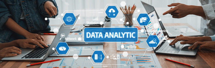 This image captures a dynamic office scene focused on data analytics. Diverse professionals collaborate using modern technology to derive business insights, showcasing teamwork and innovation. Amity