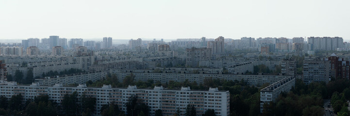 Wide panoramic view of the southern part of Saint Petersburg with Soviet-style apartment blocks, modern high-rise buildings and green areas.