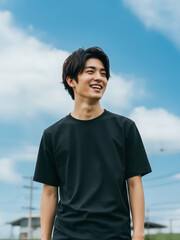 Asian young male mockup model wearing black plain T-shirt on a sunny day, outdoor fashion template