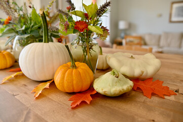Autumn seasonal table centrepiece for harvest dinner using organic, natural elements gourds,...