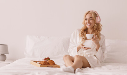 Cute female model in pink pajama enjoying morning. Pleasant happy young pretty blonde woman in...