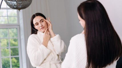Woman enjoys a relaxing skincare routine in a modern bathroom