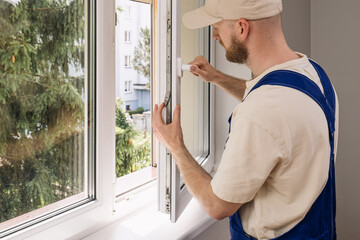 Fototapeta premium Repairman installing a PVC window frame in a residential apartment