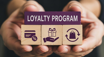 Wooden blocks with loyalty program, gift, credit card, and shopping bag icons, held in hands, showcasing a business concept of customer rewards and retention