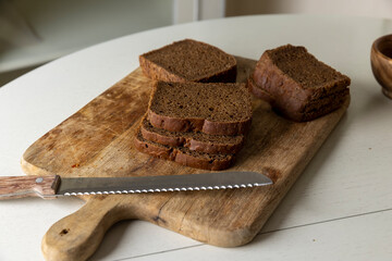 fresh black rye bread sliced for croutons on a cutting board, pieces of fresh soft sliced bread made from rye flour , bread for frying in oil with spices
