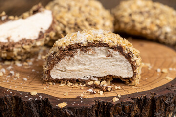 halved marshmallows in chocolate sprinkled with waffle crumbs, sweet dessert marshmallows in milk chocolate with crumbs cut in half