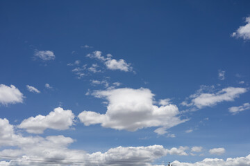 A bright blue sky filled with scattered white clouds, creating a peaceful and natural atmosphere, perfect for backgrounds and nature concepts.