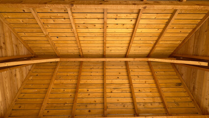 Wooden roof structure interior with exposed beams and rafters