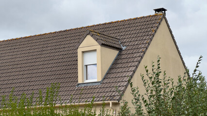Tiled roof with a dormer window and roller shutter on a modern suburban home