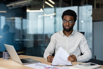 Confident businessman working with documents in modern office