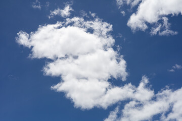 Bright blue sky with light white clouds spread across, offering a calm and natural background for outdoor and nature themes.