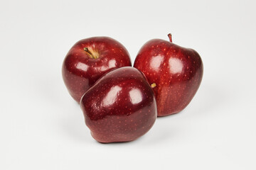 Group of red apples on a table in close-up with copy space under a white background