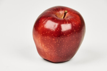 Red apple isolated on a table in close-up with copy space under a white background