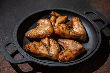 Grilled chicken wings in cast iron pan