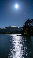 Nighttime lake scene under a bright moon