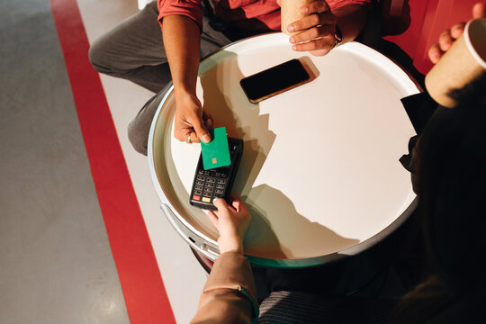 Anonymous man's hand paying with a  credit card via a pos terminal.