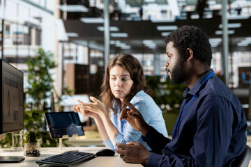 Multiethnic business people working together on global expansion strategy, using their professional...